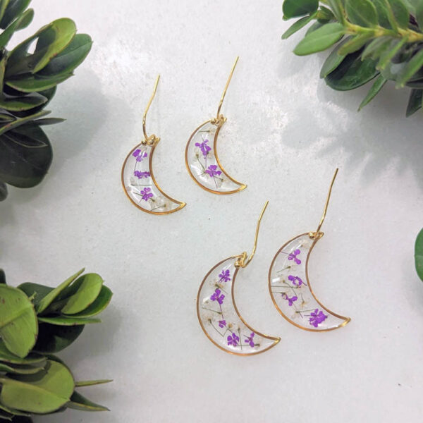 dainty gold moon earrings, transparent with real purple and white wildflowers inside